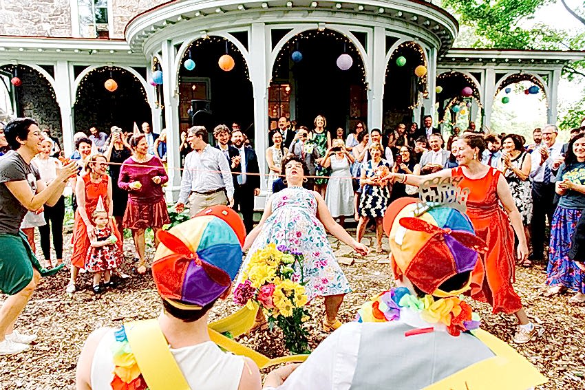 wedding guests performing for gay couple during the hora