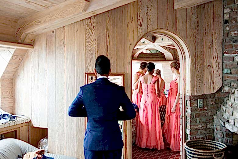 Groom getting ready for wedding and bridesmaids in the next room