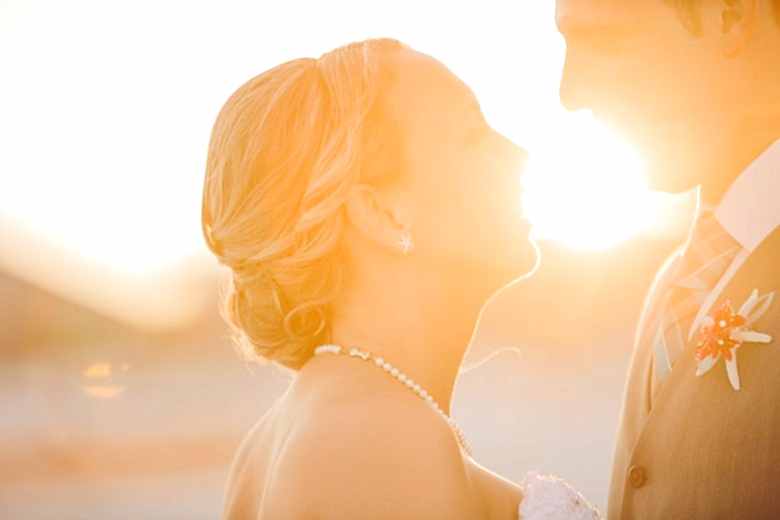 bride and groom smiling at sunset