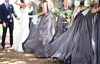 Purple bridesmaid skirts blowing in the wind