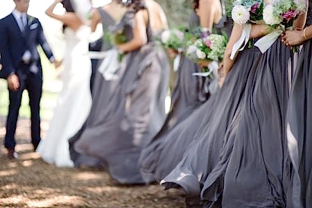 Purple bridesmaid skirts blowing in the wind
