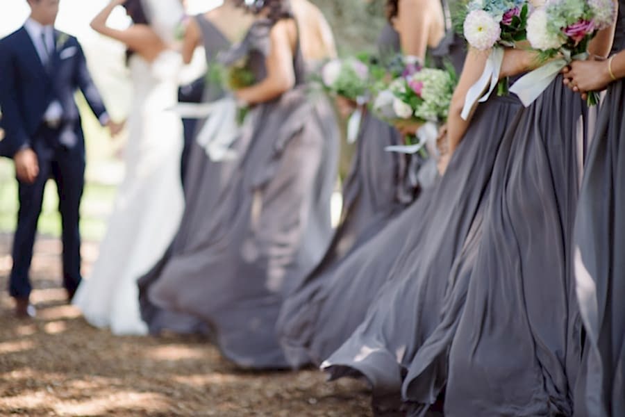 Purple bridesmaid skirts blowing in the wind