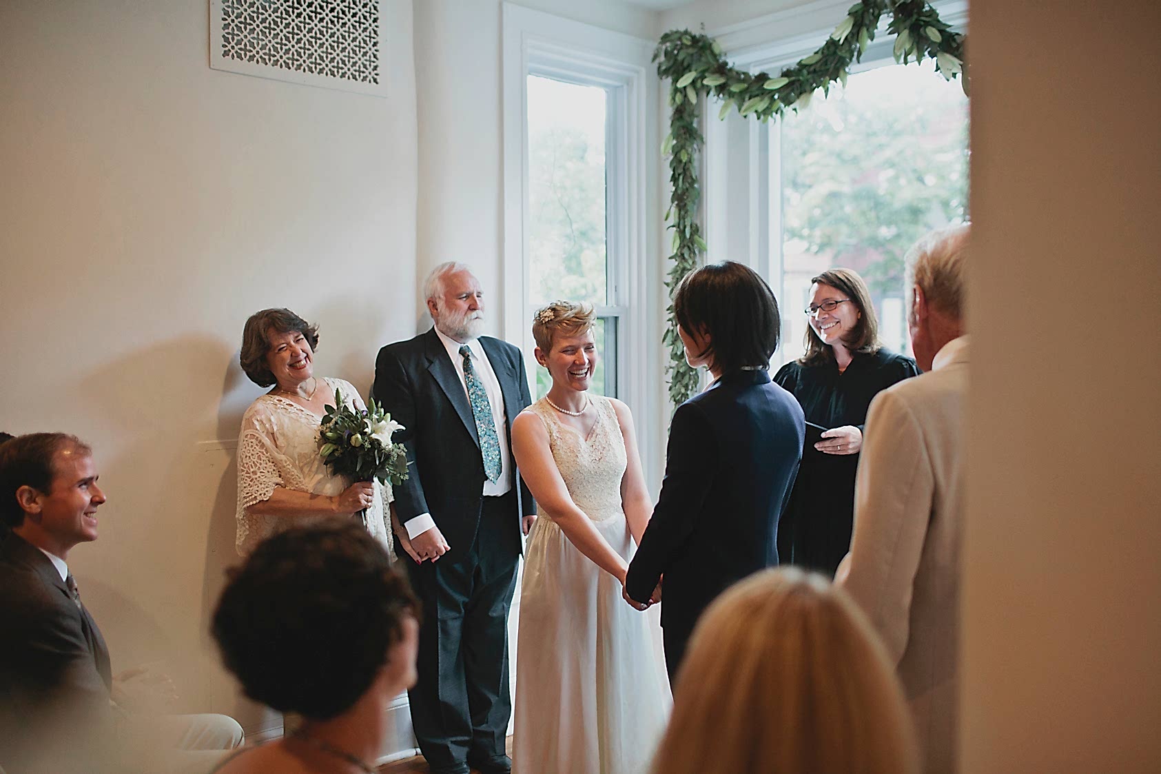 A couple getting married in a nook next to the window in their home