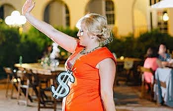 Woman dancing with a dollar sign around her neck