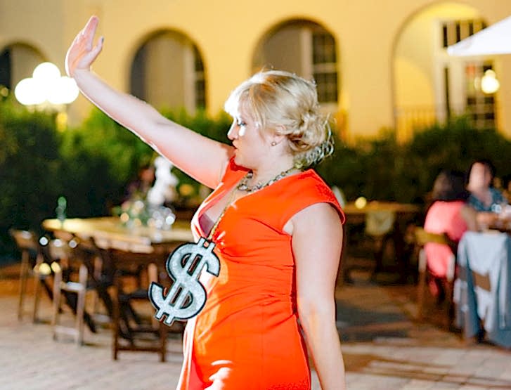 Woman dancing with a dollar sign around her neck