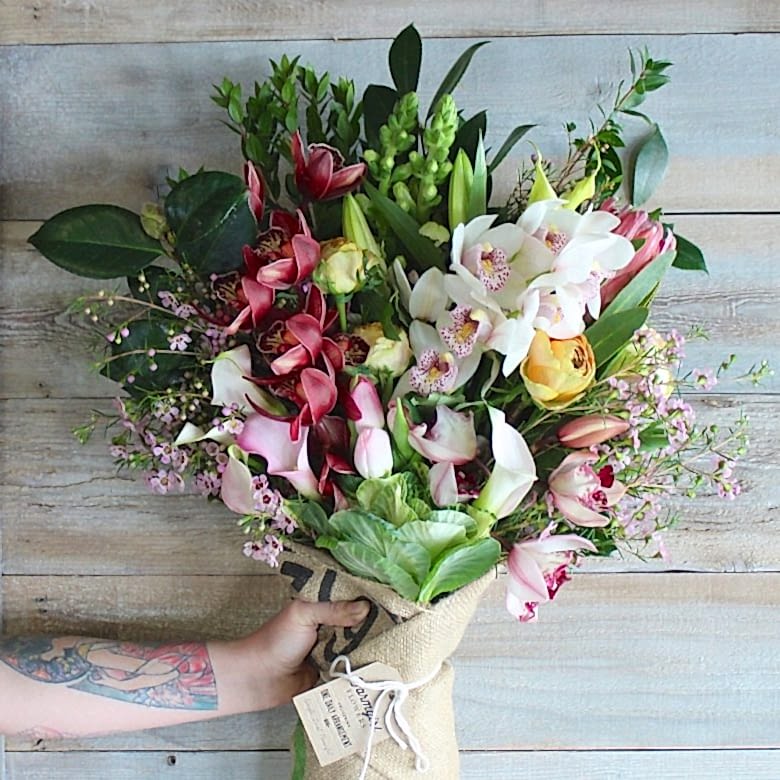 hand holding a bouquet of farmgirl flowers as an anniversary gift