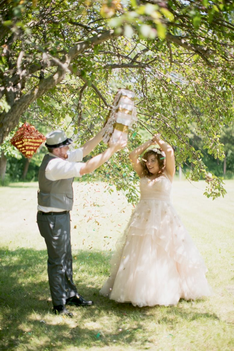 A couple hitting a matrimonial piñata at their backyard wedding