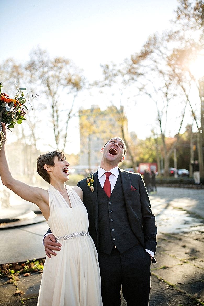 bride and groom laughing in the park