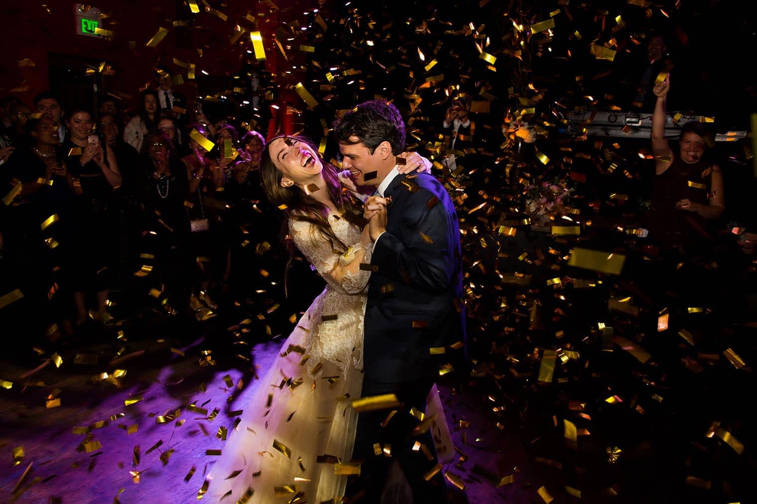 a couple is showered with gold confetti
