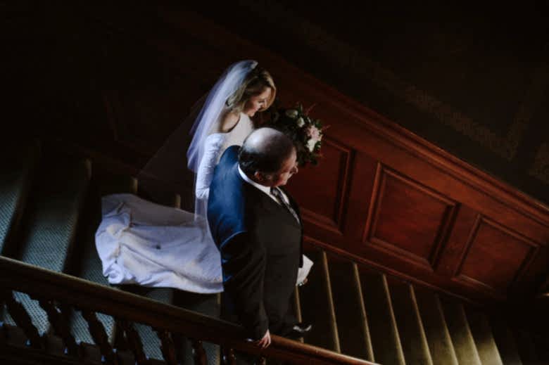 A bride walks down stairs with her father - wedding songs