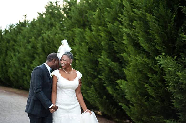 bride and groom in front of bushes and trees