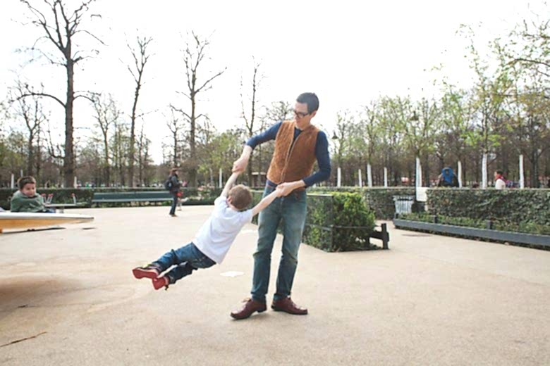 father spinning his son in the tuileries garden in paris