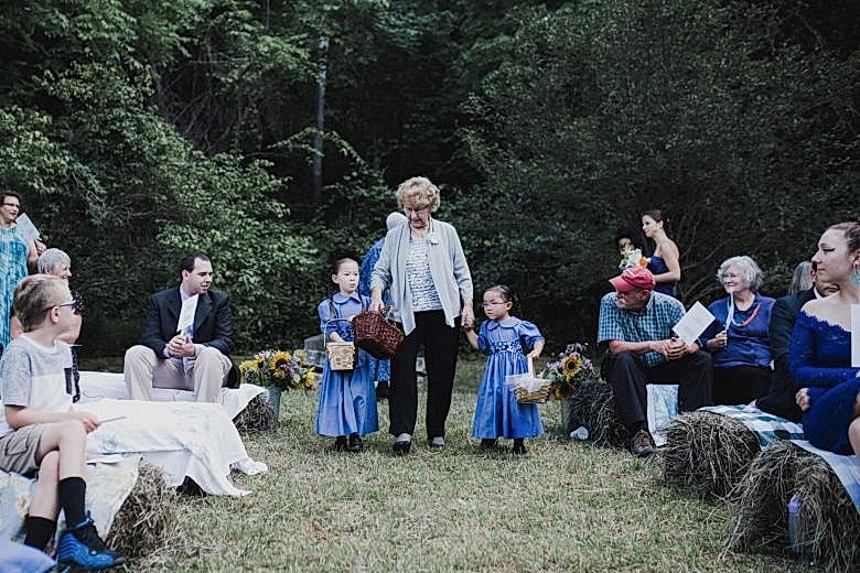 grandmother walking flower girls down the aisle