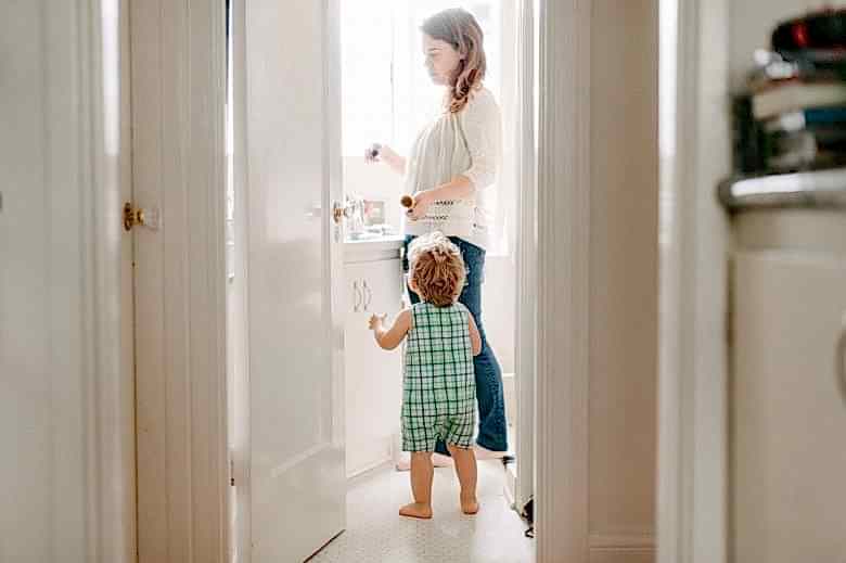 Mother with small child in white bathroom