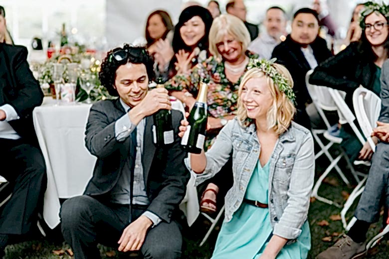 wedding guests holding champagne bottles