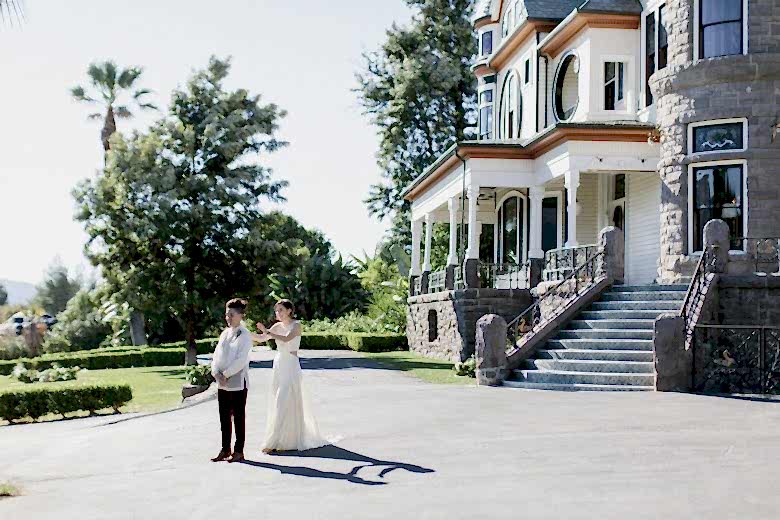couple standing outside house during first look 