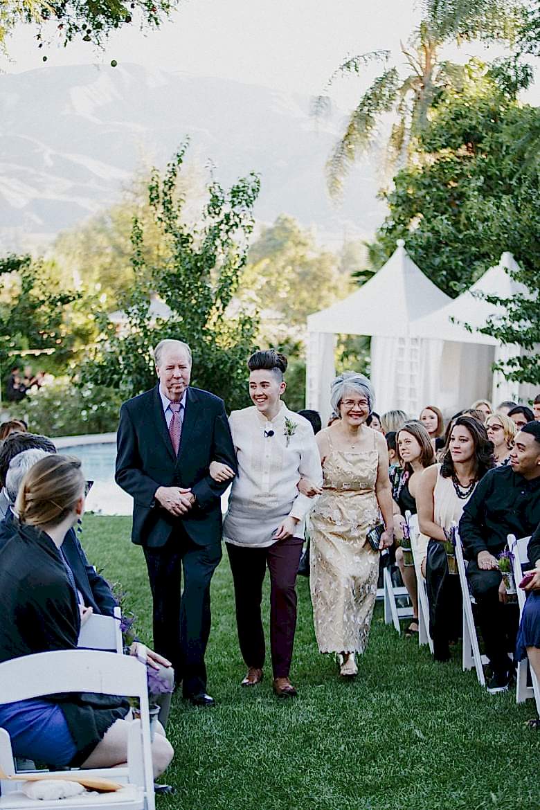 parents escorting their child up the aisle on wedding day