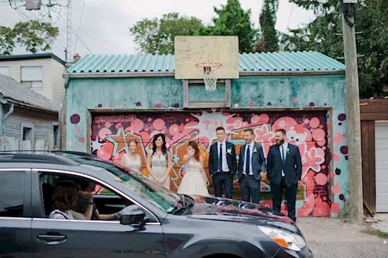 wedding party standing in front of colorful garage
