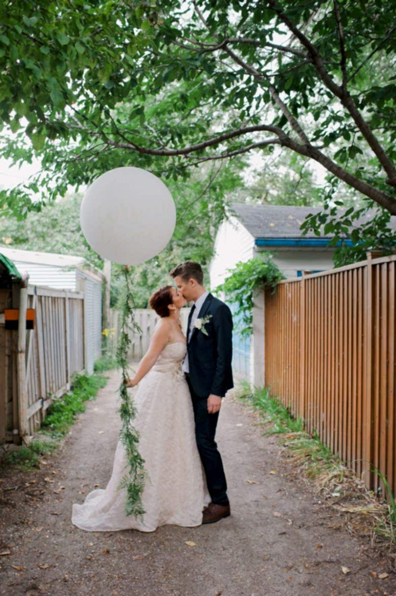 bride and groom standing with balloon