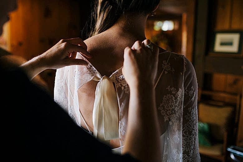 back of bride's dress being adjusted