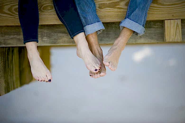 man and woman with feet touching