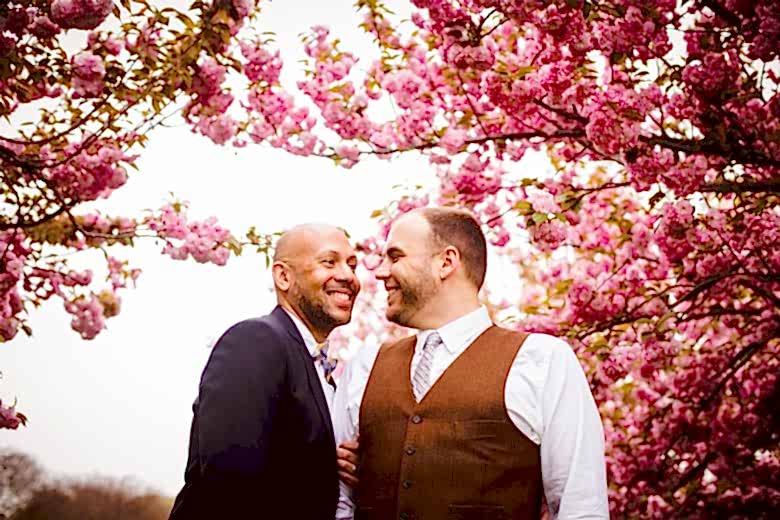 couple standing together under cherry trees