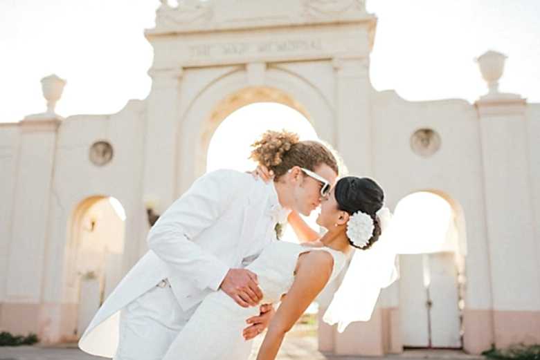 bride and groom in front of wall