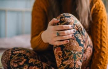woman wearing ring and holding her knee