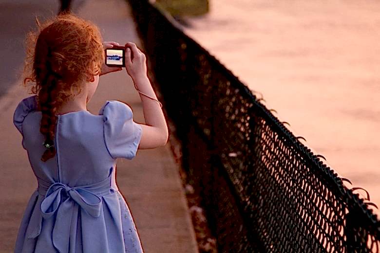 flower girl taking photo of sunset