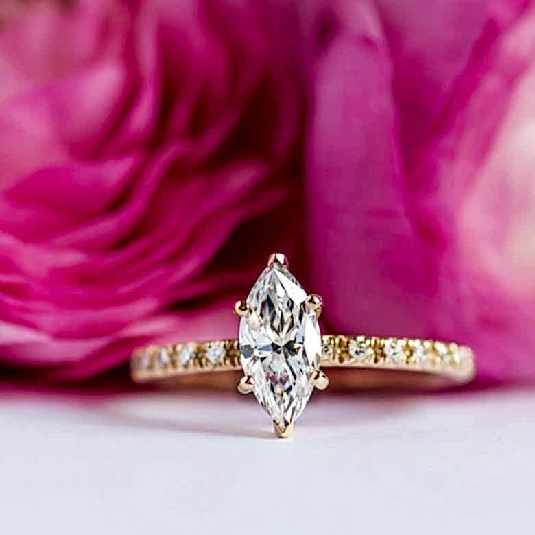 yellow gold french cut pave engagement ring nestled in roses