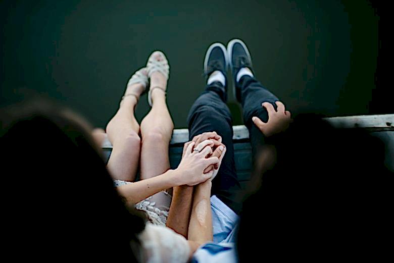 couple holding hands on a dock