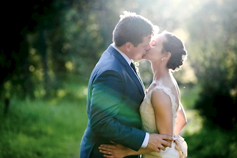 bride and groom kissing outside