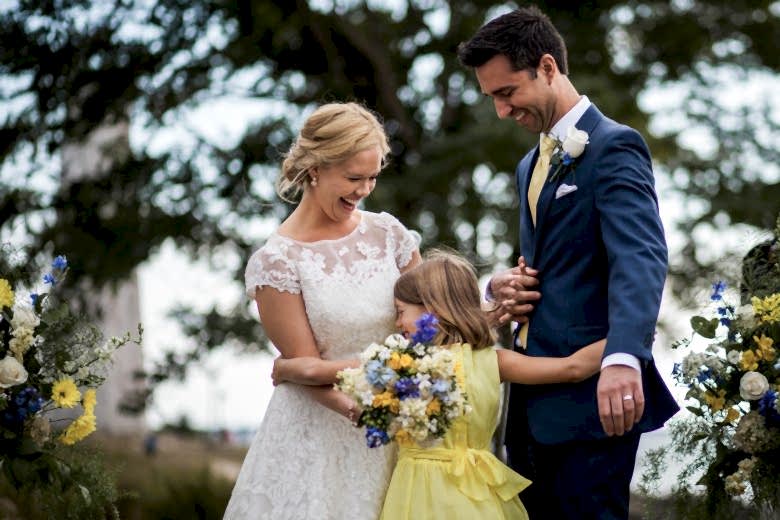 bride and groom laughing with young girl