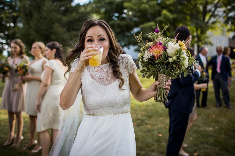 bride drinking mimosa on her wedding day