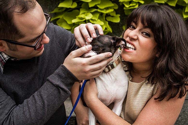couple in a photo with their dog