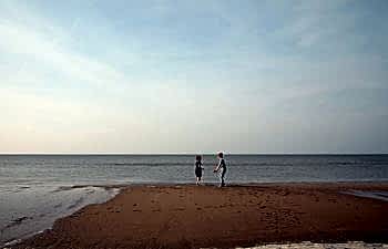 two children playing by the ocean