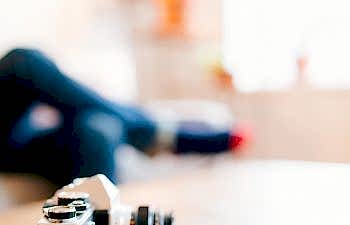 close up shot of a camera with a woman in the background