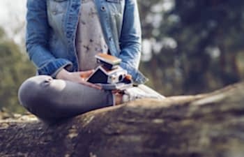 woman sitting on a tree with a camera