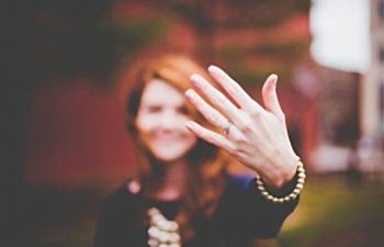 woman showing her engagement ring to a camera