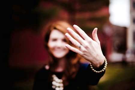 woman showing her engagement ring to a camera