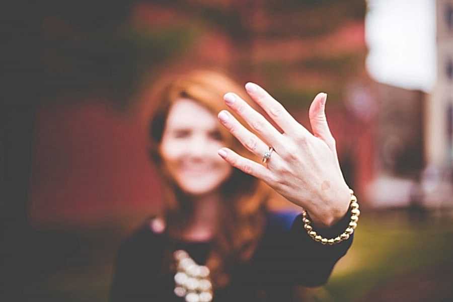 woman showing her engagement ring to a camera