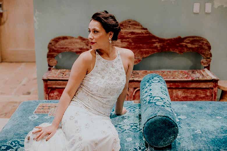 bride wearing BHLDN starling gown on a blue velvet anthropologie sofa