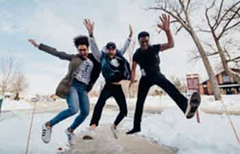 two men and a woman jumping