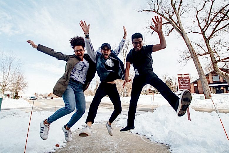 two men and a woman jumping