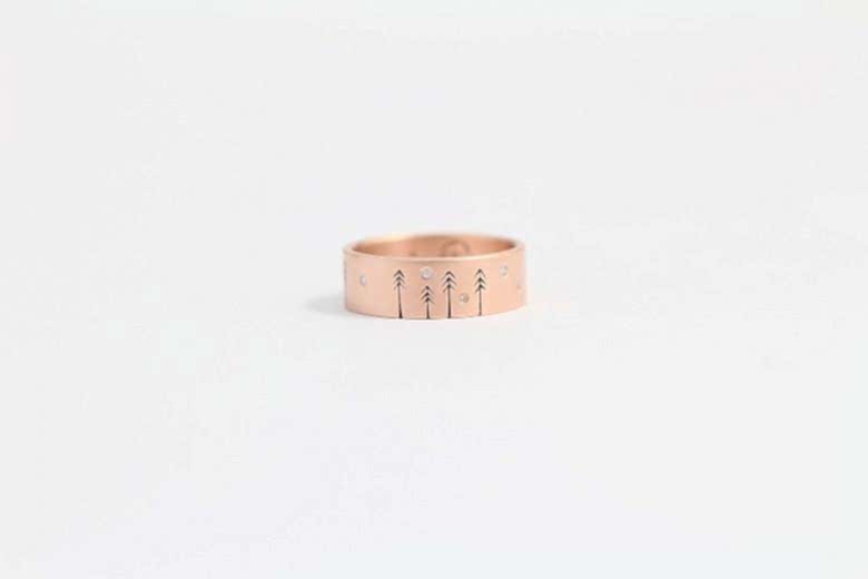 wedding ring from ash hilton with etched pine trees and inset small diamonds