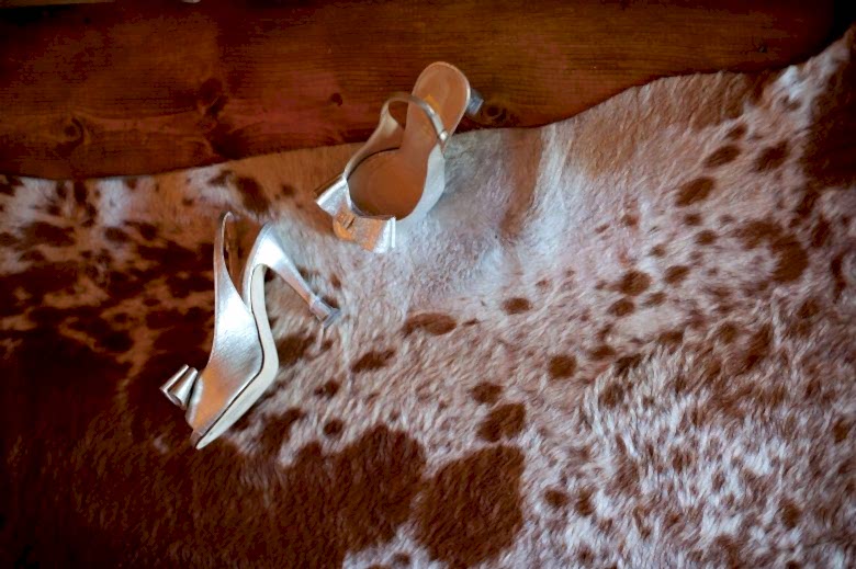 gold shoes on a cow rug