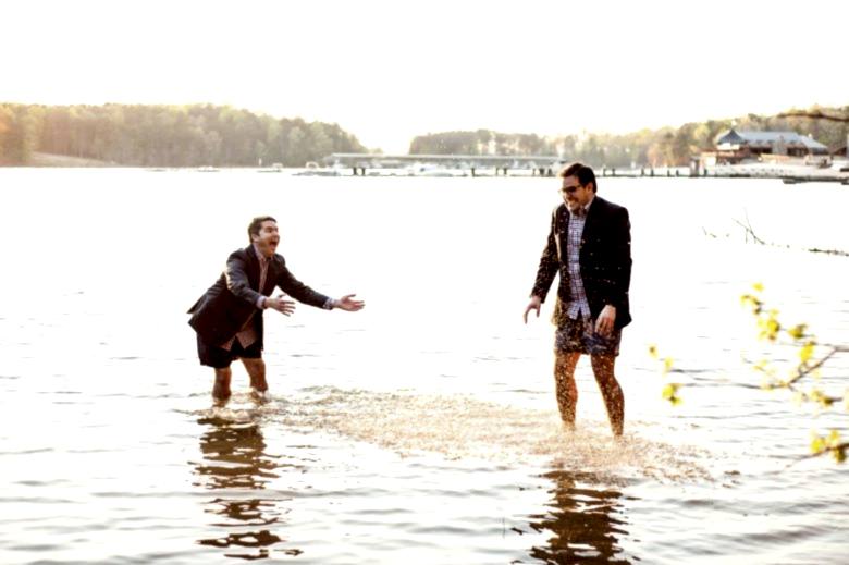 two men playing in a lake by you are raven