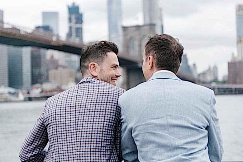 portrait of two grooms from behind, looking at Brooklyn Bridge and Manhattan skyline