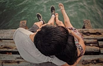 a couple sitting on a dock together