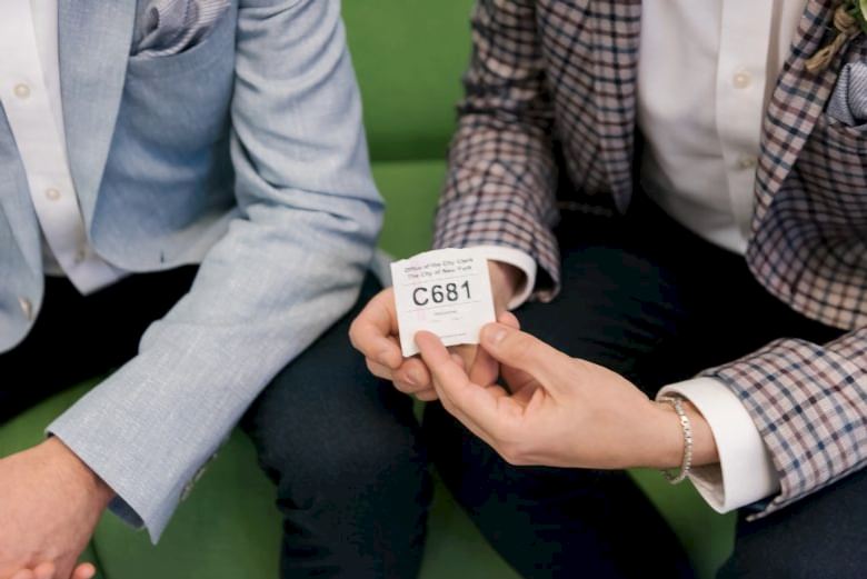 grooms' hands, one holding their queue number